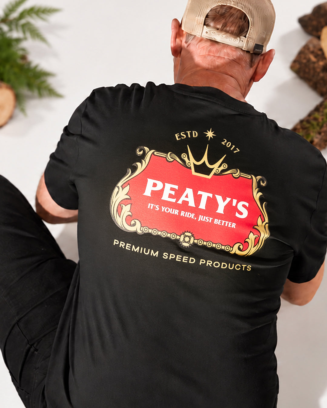 Close-up of the red and gold Thirsty Work graphic on the black Peaty's T-shirt