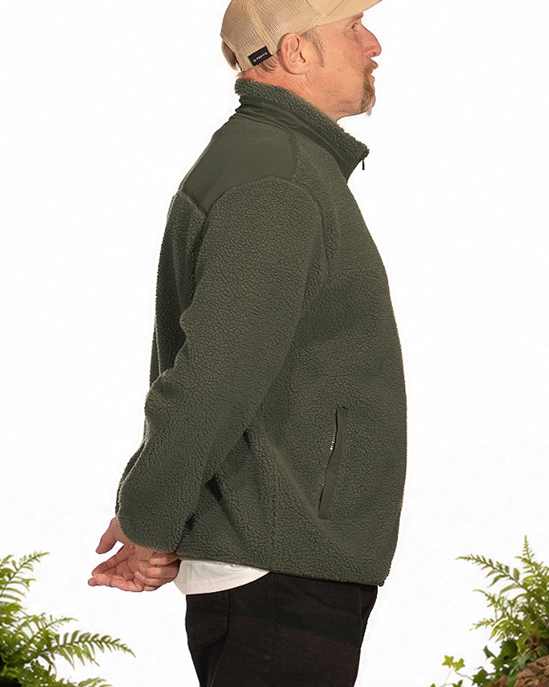 Steve wearing the khaki Peaty's Wharncliffe Fleece in side profile, with ferns