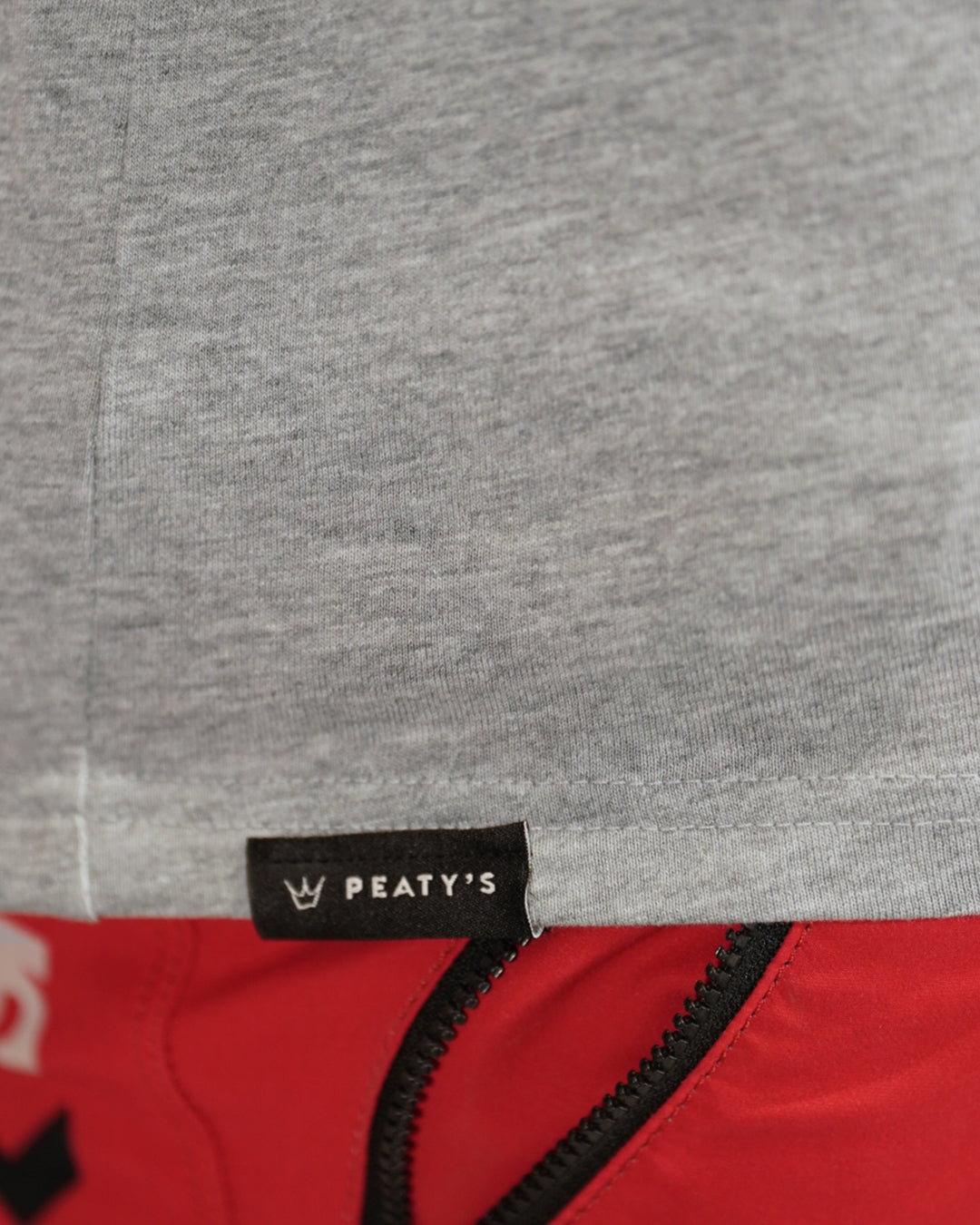 Close-up of the Peaty's woven hem label on Heather Grey Mountain T-shirt